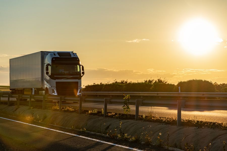 paisaje soleado con camión de transporte por carretera